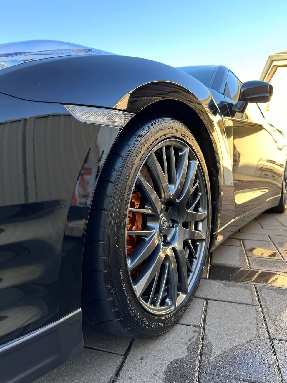Glossy black Nissan GT-R with a clean wheel and dressed tyre