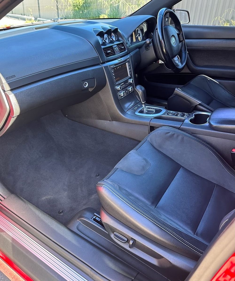 Clean carpet, leather and suede seat and dashboard inside a red sports sedan