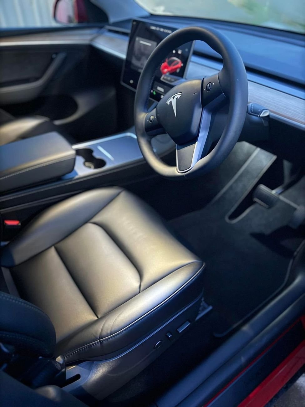 Clean black leather front seat inside a Tesla Model Y